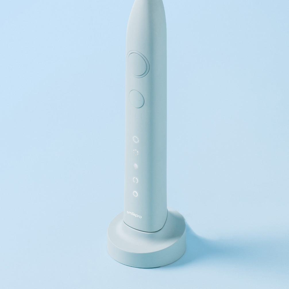 SmilePro sonisk tandborste i Soft Mint på sin laddningsstation