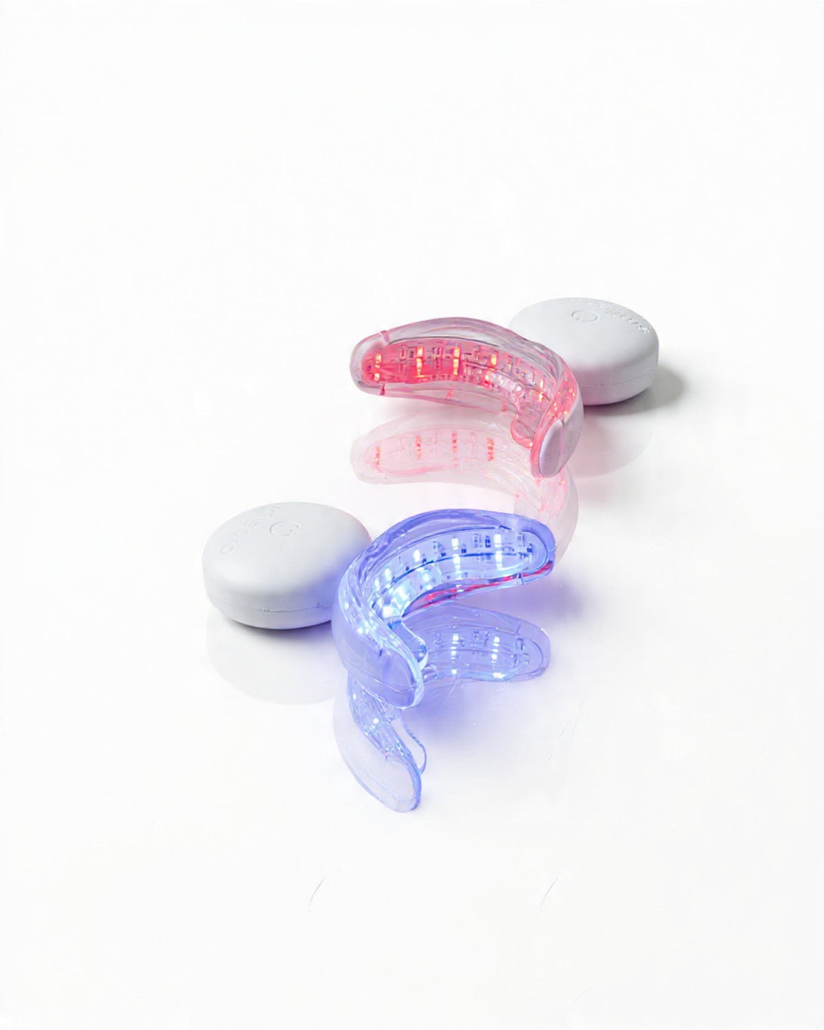 Two SmilePro LED mouthpieces, one glowing blue and one glowing red